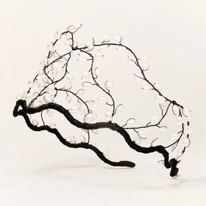 Détail de la branche de perles tressée à la main sur un serre-tête chic à couronne haute