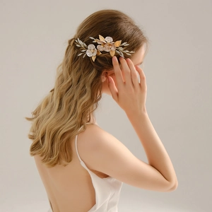 Détail d'un peigne à cheveux de mariée avec fleurs, perles et cristaux sur cheveux bouclés