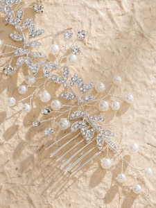 Détail du peigne de mariée avec perles et strass sur fond beige texturé