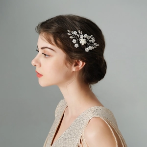 Elegante pettine per capelli da sposa con perle e fiori bianchi su un'acconciatura formale
