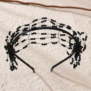 Detail of handcrafted black beaded floral headband with intricate wave weave and pearls