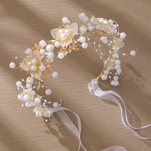 Détail d'un serre-tête de mariée fait main avec fleurs dorées et perles blanches