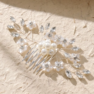 Vista macro dettagliata del pettine da sposa fatto a mano con perle e fiori di cristallo