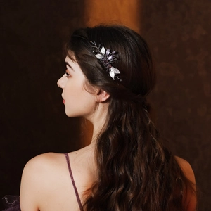 Detail view of handmade bridal hair comb with purple crystals and silver leaves on model
