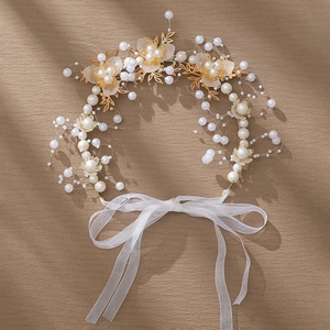 Détail du bandeau de mariée avec feuilles dorées, perles et ruban en organza