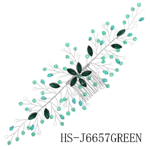 Detailed close-up of handmade bridal hair comb with green crystals and silver wire vines