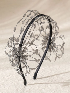 Detailed close-up of handmade beaded floral headband with black woven mesh and pearls
