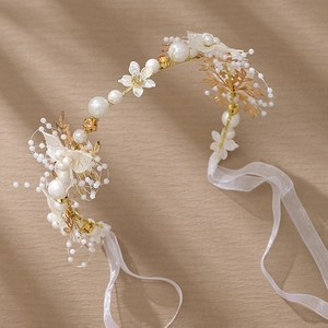 Détail de serre-tête mariage avec perles, strass, fleurs de soie et rubans blancs