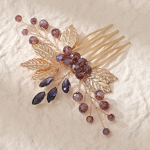 Detailed close-up of handmade bridal hair comb with gold leaves and purple crystal beads