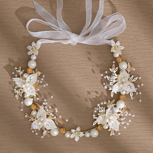 Détail de bandeau de mariée artisanal avec fleurs en dentelle et perles ivoires