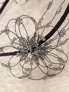 Close-up of handmade beaded floral headband with grey crystal beads on black metal