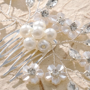 Dettaglio macro del pettine per capelli da sposa con perle, cristalli e fiori in resina