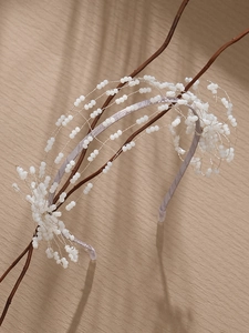Detail of bridal headband featuring white handmade beads and delicate floral wire design