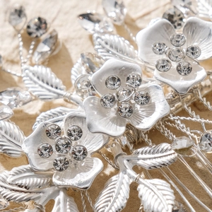 Dettaglio ravvicinato di pettine per capelli da sposa con fiori d'argento e strass
