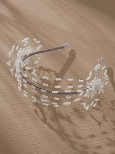 Detailed macro view of handmade white beaded floral clusters on an elegant bridal headband