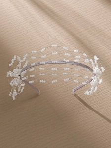 Detailed view of handmade bridal headband with white beads and floral accents