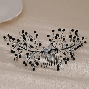 Close-up of handmade bridal hair comb with black beads and crystal flower on silver wire