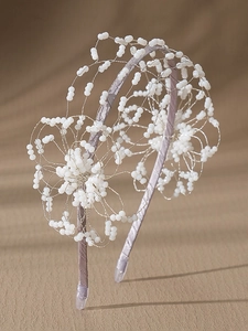 Detail of handmade beaded floral bridal headband with purple satin finish and white beads