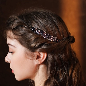 Detail of vintage bridal hair comb with purple rhinestones on elegant dark brown hair