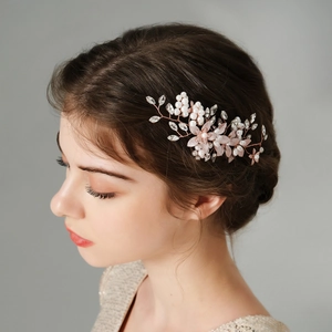 Dettaglio del pettine da sposa con perle e cristalli su filo d'oro rosa per capelli