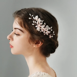 Dettaglio del pettine da sposa fatto a mano con perle, fiori rosa e cristalli su oro rosa