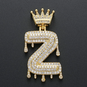 Close-up of golden hip hop letter Z pendant with crown and dripping effect with zircons