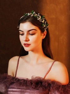Détail d'un bandeau de mariée avec feuilles d'acrylique vertes et perles blanches