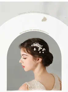 Close-up of handmade bridal hair comb with cream pearls and gold vine wire details