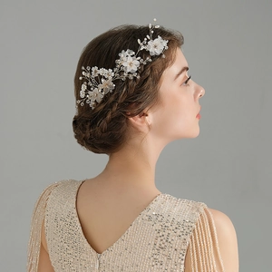 Close-up of handmade bridal hair comb with white fabric flowers and crystal beads