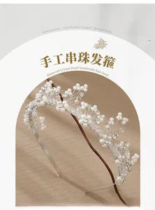 Detailed close-up of handmade bridal headband with white pearls and sparkling crystals