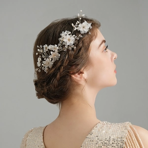Detail of handcrafted bridal hair comb with pearls and translucent flowers on gold wire