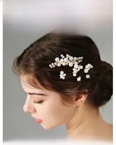 Detail of bridal pearl hair accessories set with gold wire on a brunette hair styling
