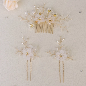 Elegant bridal floral hair comb and pins set with white petals, pearls, and gold finish
