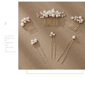 Detailed view of handcrafted pearl bridal hair comb and pins with elegant gold metal finish