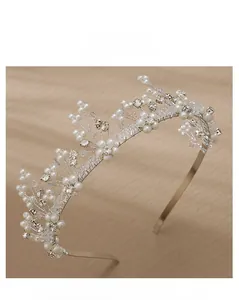 Close-up of handmade bridal headband with white pearls and clear faceted crystals on silver wire