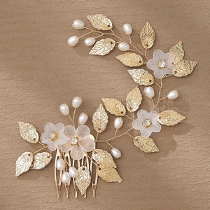 Detailed close-up of handmade bridal hair comb with gold leaves and pearl flowers