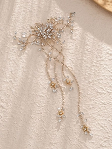 Detail of bridal hair comb with gold leaves, rhinestones and elegant long tassels