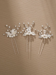 Detailed view of three handcrafted pearl and rhinestone flower hair pins for weddings
