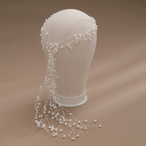 Detail of elegant bridal hair accessory with long white pearl tassels for weddings