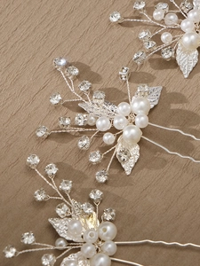 Detail of silver bridal hair pins with pearls, rhinestones and hollow alloy leaves