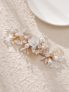 Détails du peigne de mariée avec fleurs blanches à la main, perles et feuilles dorées