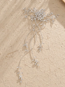 Macro shot of silver bridal hair comb with glittering rhinestones and long tassel details