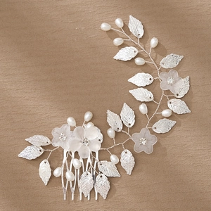 Silver bridal hair comb with vintage floral leaves and faux pearls on brown background