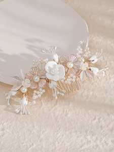 Détail du peigne de mariée avec fleurs blanches artisanales, perles et feuilles dorées