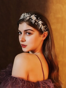 Detail of bridal headband with sparkling crystals and pearls on model's hairstyle