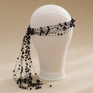 Detailed macro view of black layered beaded headband with elegant dangling tassels