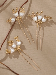 Detail of handmade gold bridal hair pins with white lily of the valley flowers