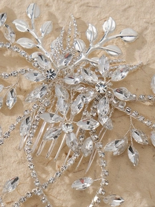 Macro detail showing silver floral leaves with sparkling marquise rhinestones on a bridal comb
