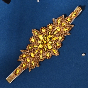 Gros plan de strass ambre et fleurs en cristal sur bandeau élastique blanc pour mariée