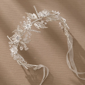 Detailed view of silver bridal hair band with white pearls, crystals and floral metal leaves
